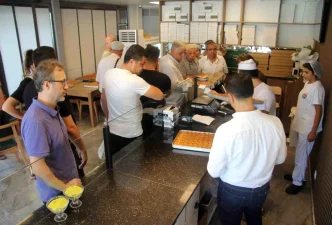 Ogrencilerin uygun fiyata urettigi baklava icin siraya giriyorlar